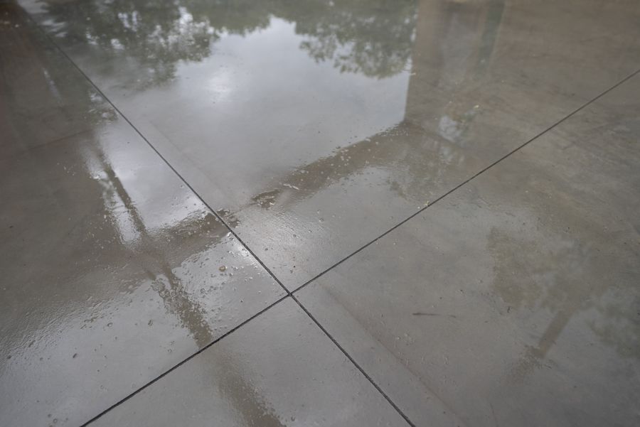 Saw-cut joints in the slab, wet after rain.