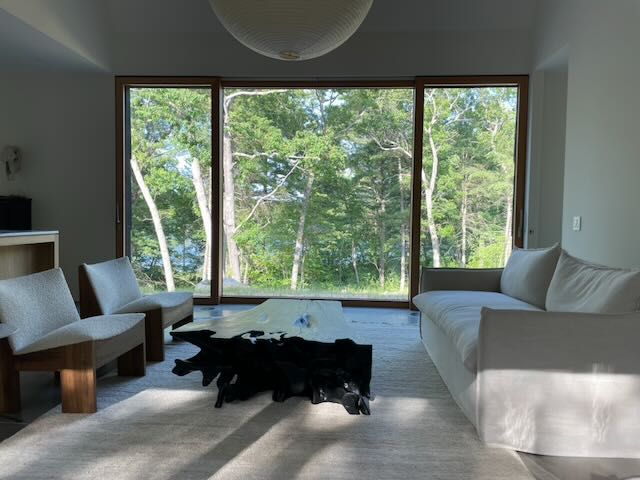 The triple-burnt teak table between the sofa and the lounge chairs.