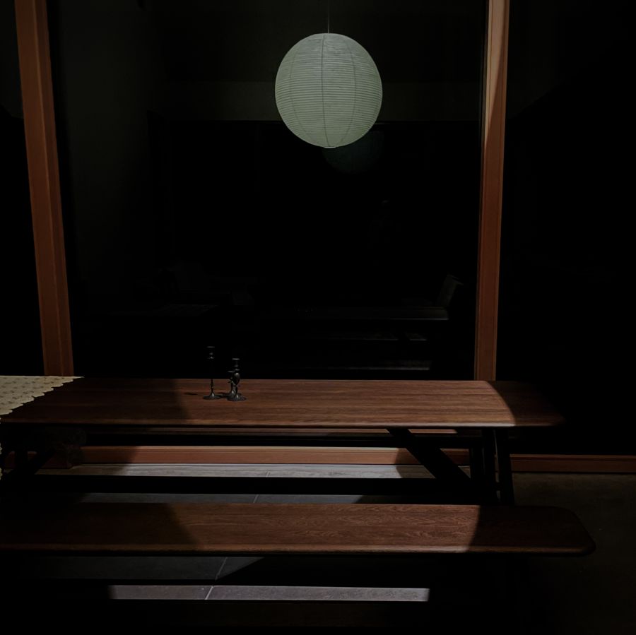 The dining table and benches under the Akari lantern, by moonlight.