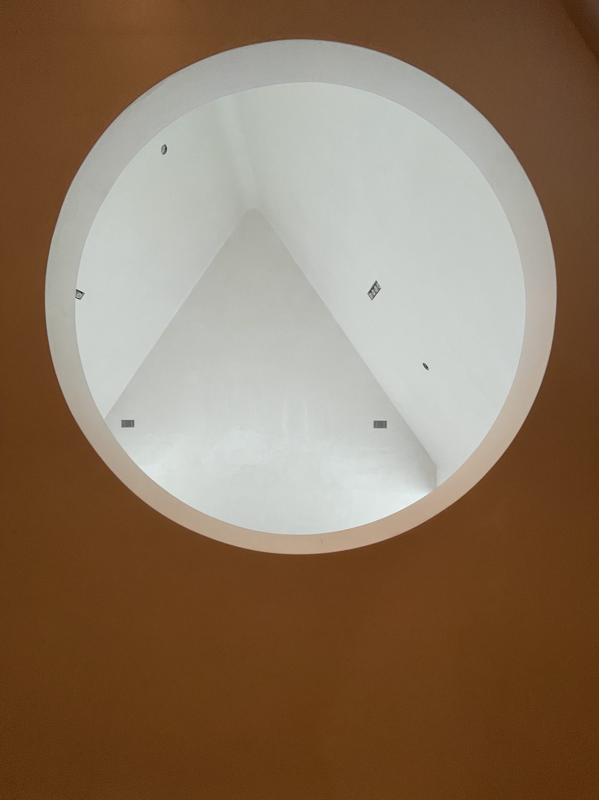 A large circular opening on the second floor overlooking the main living space