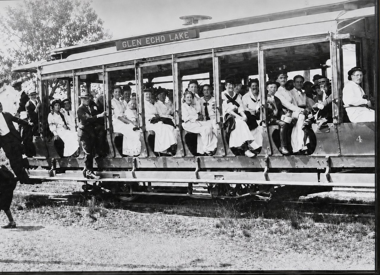 Historical photo of an open trolley car full of passengers, its destination board reading Glen Echo Lake