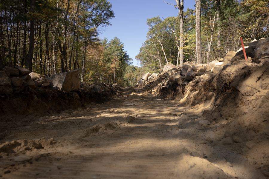 The access road cut through ledge and forest.