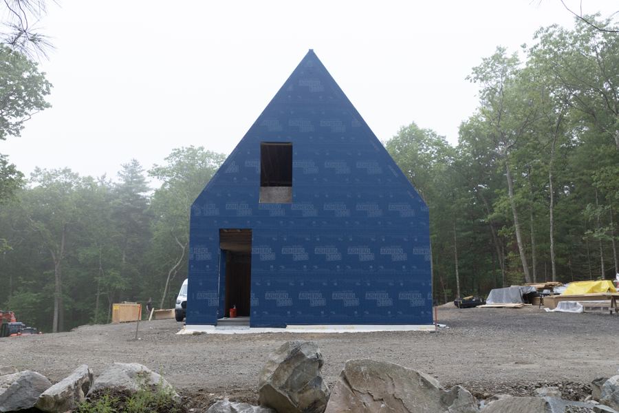 The gable wrapped in its blue weather barrier.