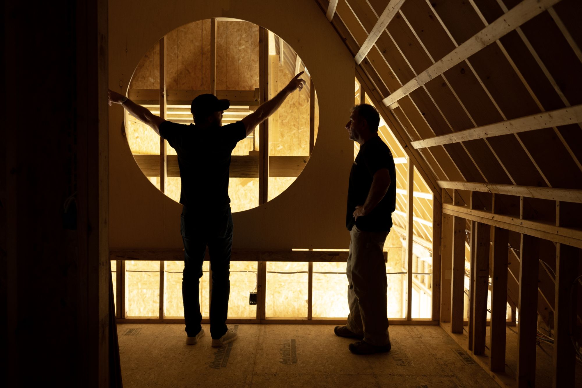 Two people silhouetted before the circular opening on the second floor
