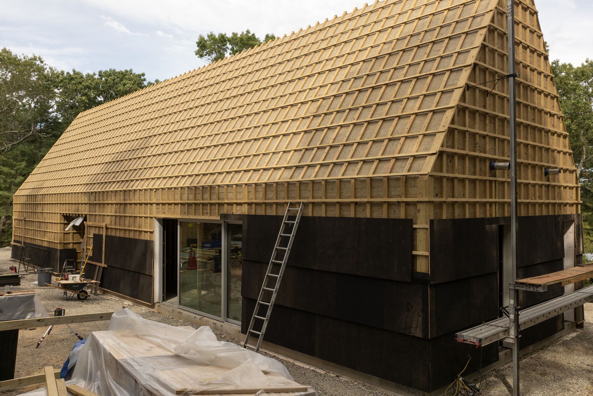 The shingle field partly installed over battens on the long side of the house